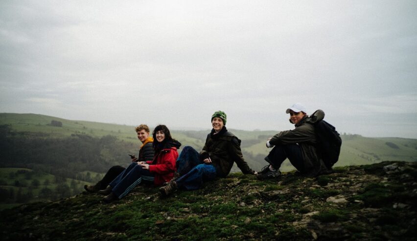 four young people sat on the top of a mountain
