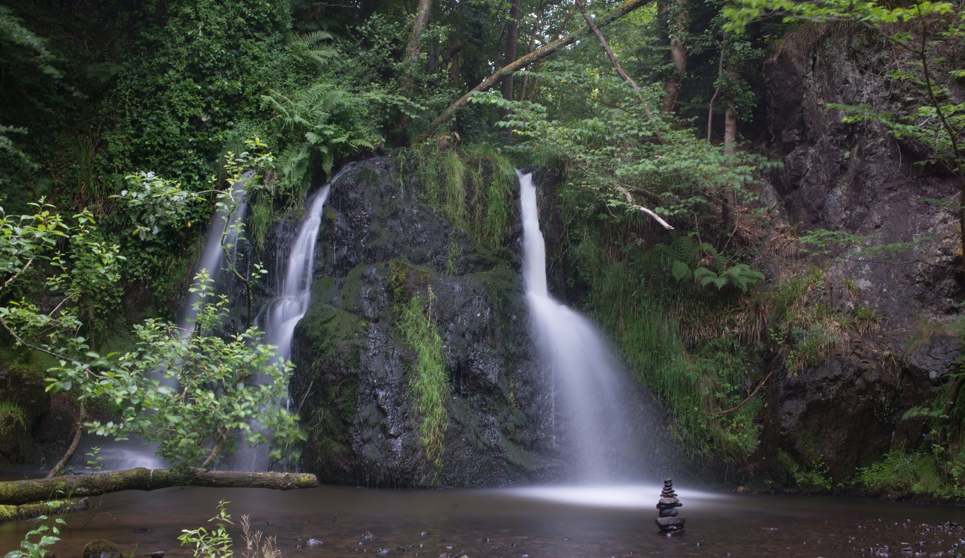 A fairy glen in easter ross. the image depicts a waterfall flowing down into a pool