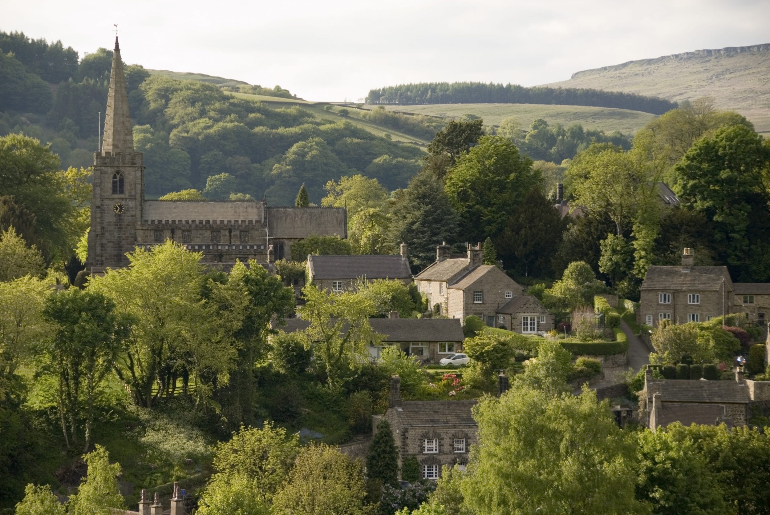 Hathersage village and church nestled in the rolling hillsides of the Peak District, Derbyshire UK