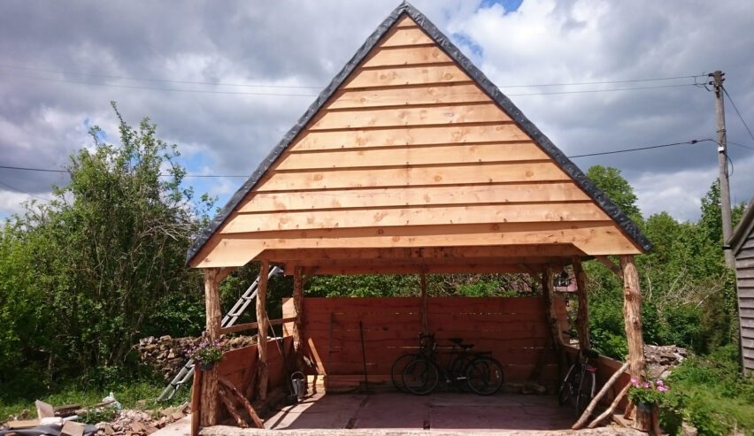 Attreactive wooden swiss chalet style bike shed with a couple of bikes in