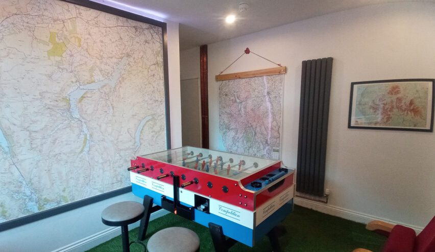 Small room with maps on the wall and football table