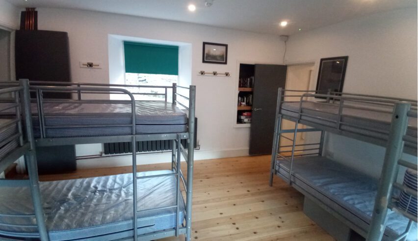 Woodem florred dormitory with 2 set os meteal unmade up bunks
