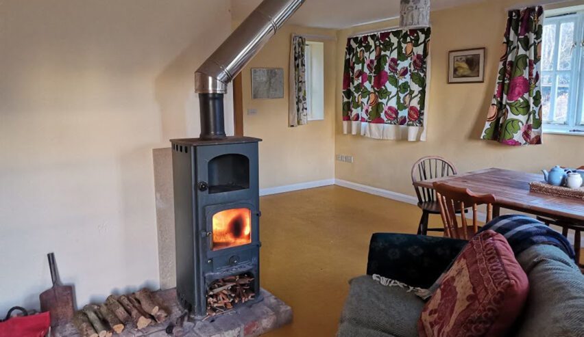 Blazing woodburner in pretty lounge at Station Cottage Hostel Colwall