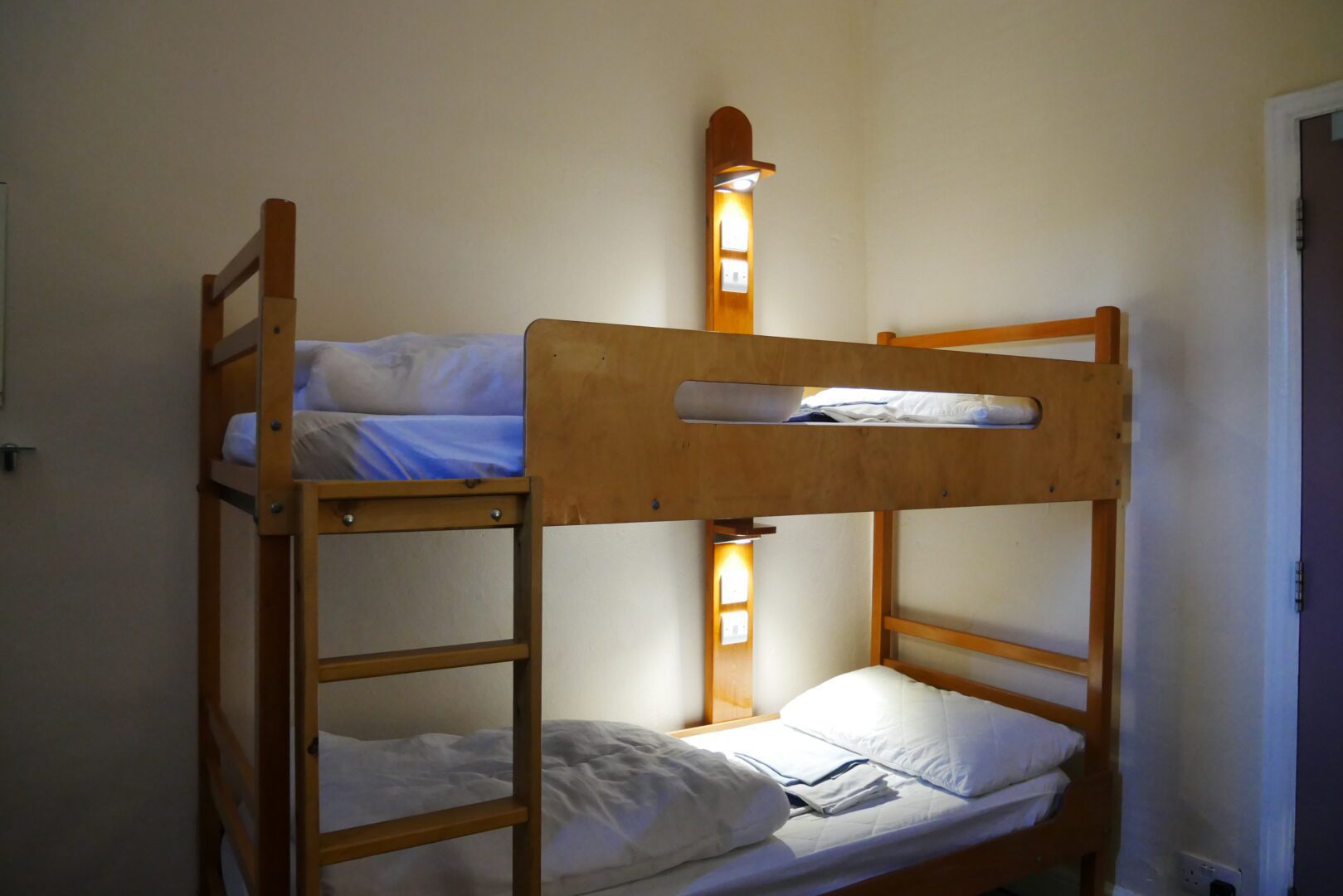 a picture of two bunkbeds lit by two lamps