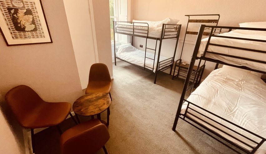 Quad room with two set of metal bunks and a table and chairs