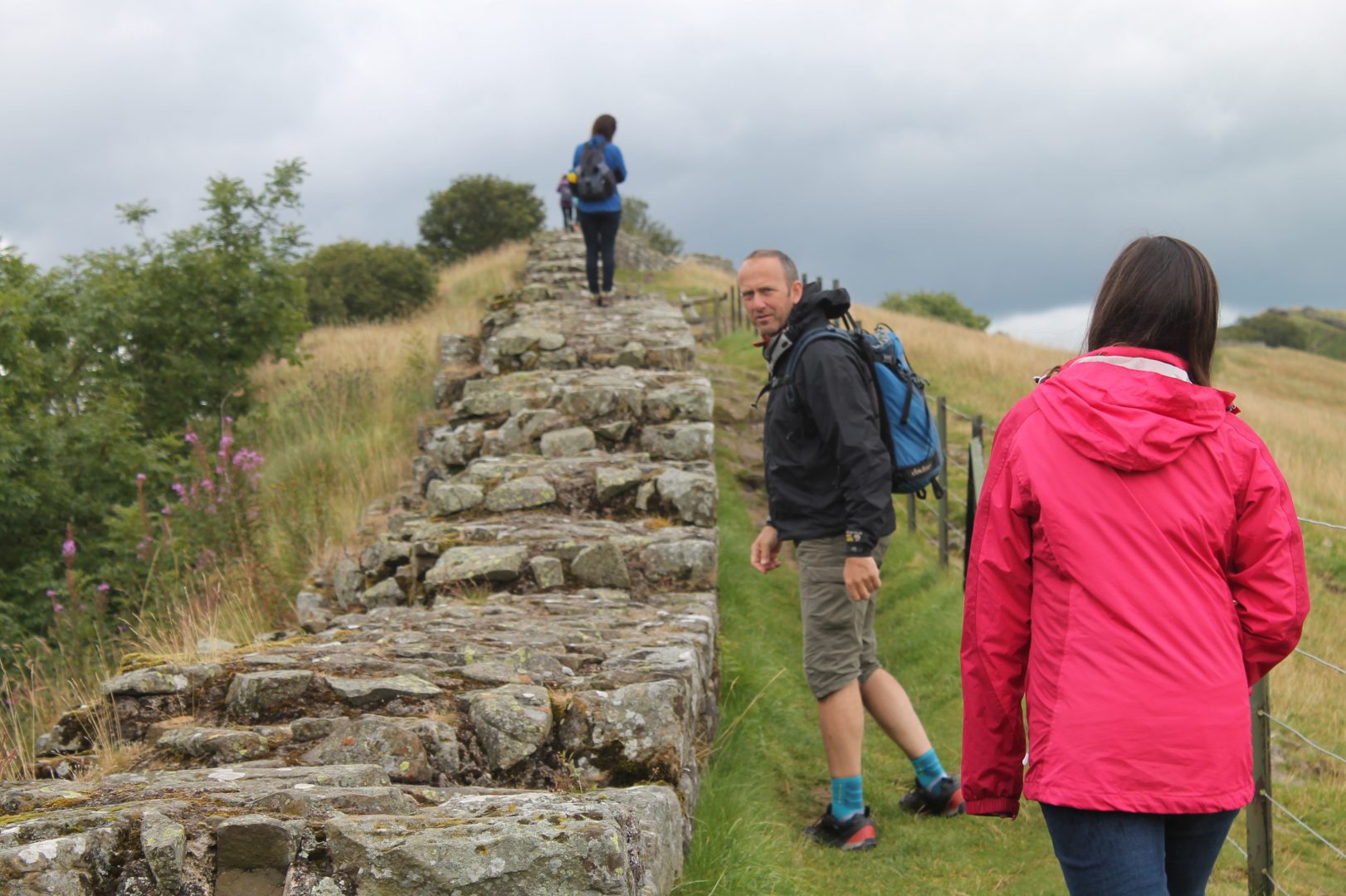 Three people walking along hadrian's wall path