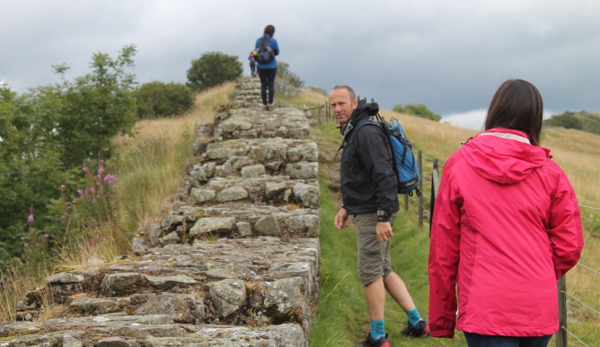 Three people walking along hadrian's wall path