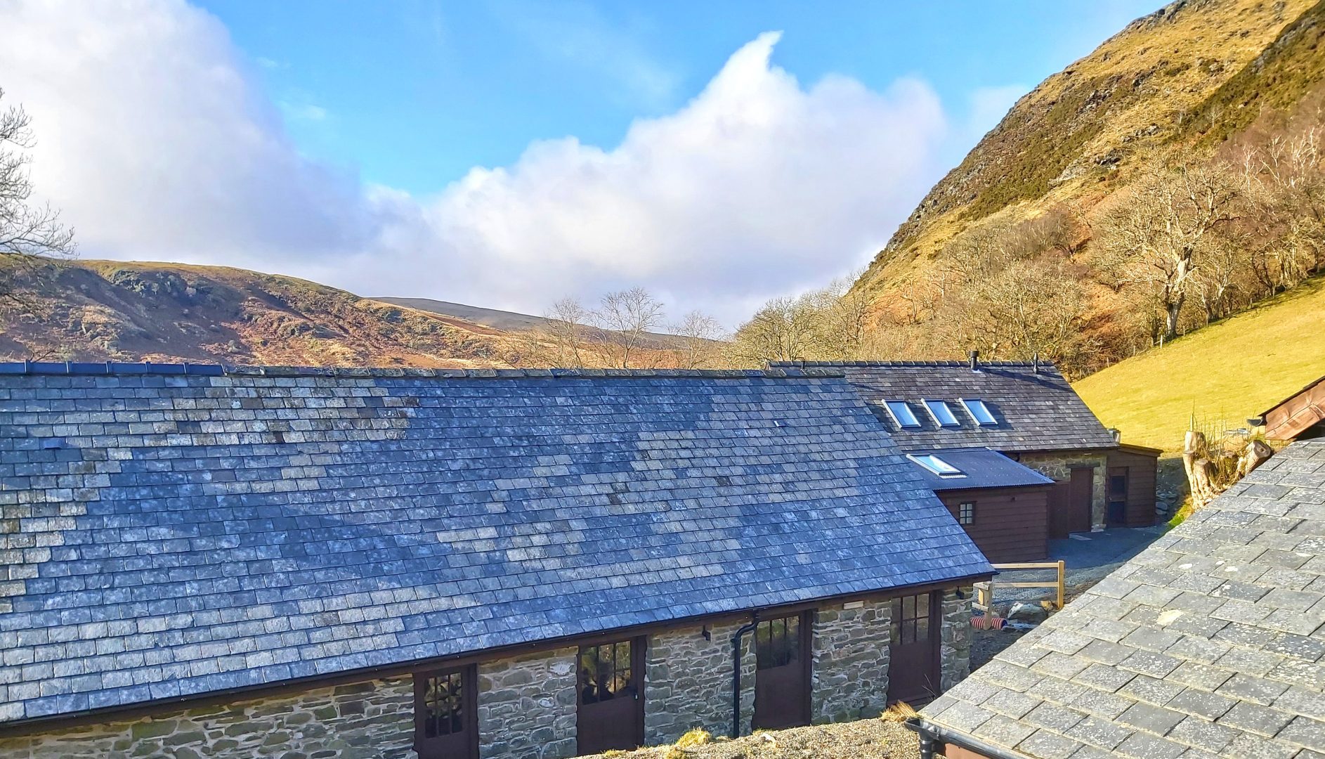 One long stone bunkhouse building with hills behind