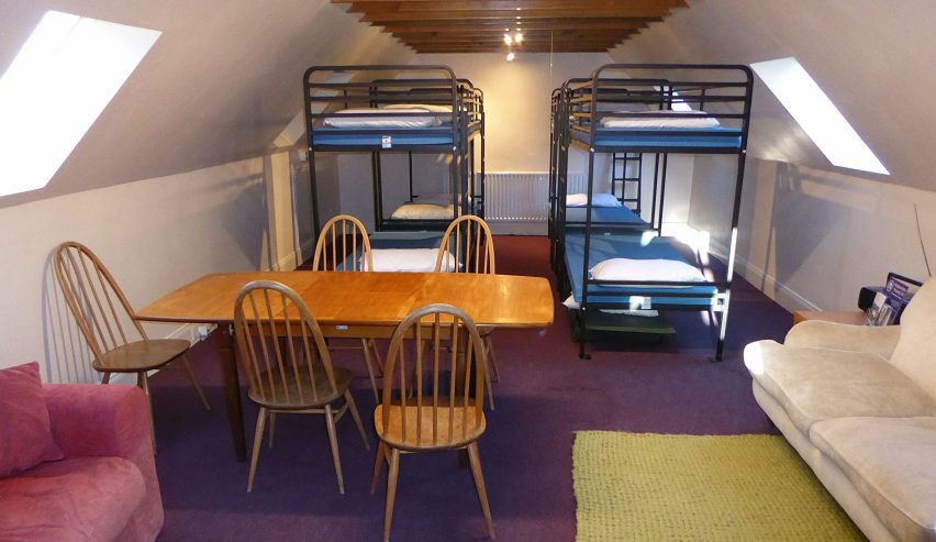 The bunkroom, with bunks at the back and table and chairs in the foreground