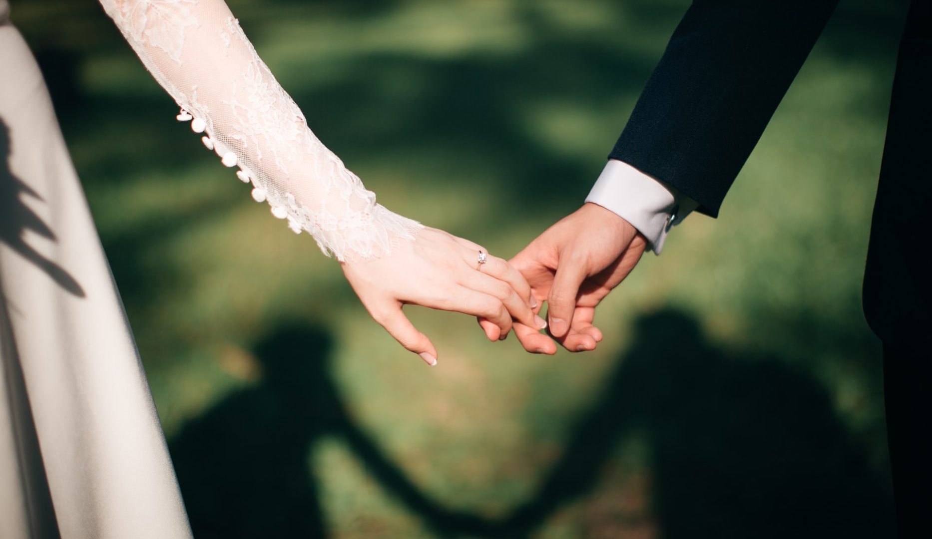 A close up picture of a man and a wife holding hands.
