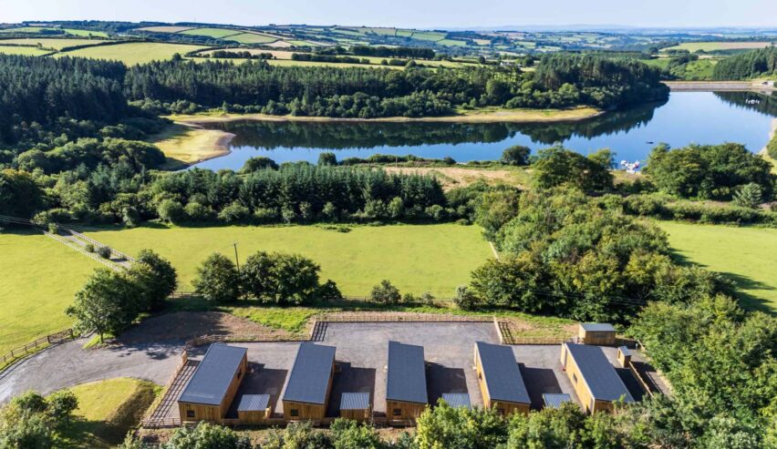 Overhead view of Calvert Devon Lodges showing five lodges and rhe lakes and fields and woods landscape beyond