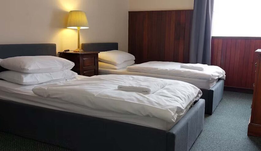 Twin bed room at Mar Lodge Bunkhouse showing crisp white bedlinen
