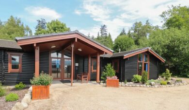 outside view of the front of Shore Lodge Arran National Trust for Scotland Bunkhouse showing lots of window area and flat entrance