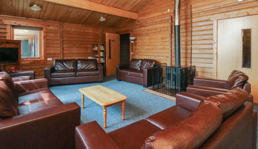 comfy lounge with sofas and log burners at Shore Lodge Arran National Trust for Scotland Bunkhouse